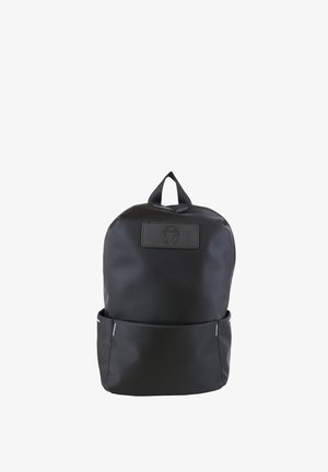 Sac à dos noir avec poche avant et poignée supérieure, design minimaliste, et un patch logo circulaire sur le panneau supérieur avant.