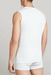 Canottiera bianca senza maniche e boxer coordinati realizzati in un tessuto liscio e elastico, design aderente, mostrando linee pulite e una vestibilità attillata.