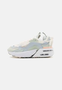Zapatillas deportivas con un diseño por capas en verde claro, blanco y rosa pálido. Materiales de malla y ante con una suela gruesa y amortiguación de aire visible.