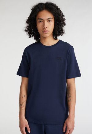 T-shirt in cotone blu navy con maniche corte e scollatura rotonda, caratterizzata da un logo nero discreto sul petto e una texture liscia.