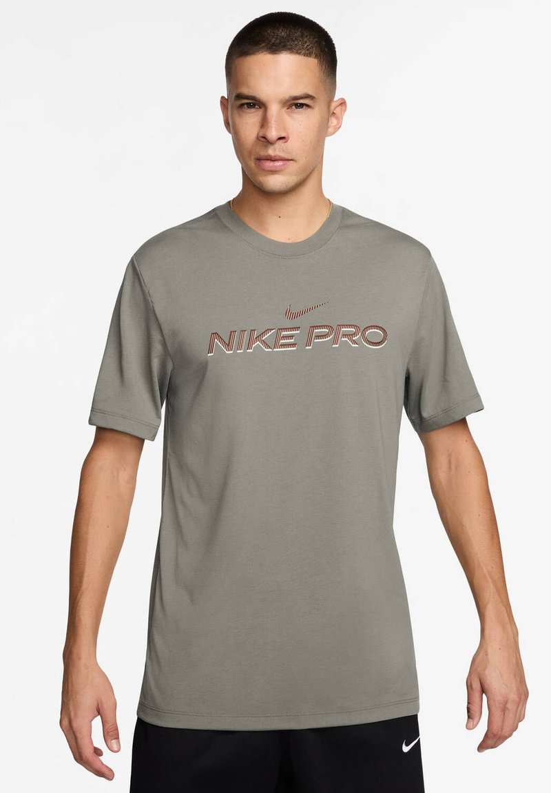 Nike Pro T-särk salveiroheline, lühikeste varrukatega, ümar kaelus, kus on silmapaistev "NIKE PRO" tekst kontrastse värviga. Sile kangast tekstuur.