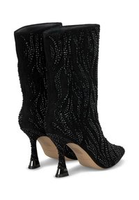 Botines negros de ante texturizado, con un patrón de ondas creado por Strass negros y tacones stiletto delgados con acentos metálicos.