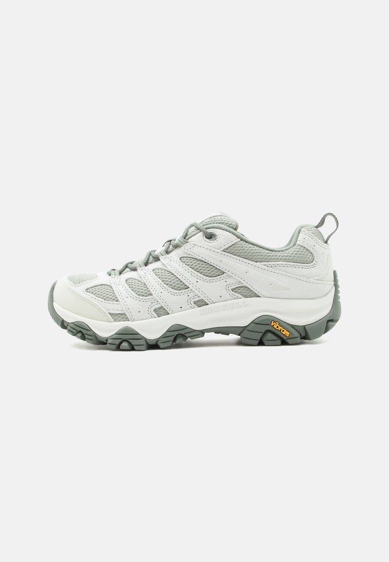 Chaussure de randonnée gris clair et blanche avec panneaux en mesh, lacets à l'avant, col rembourré et logo Vibram sur une semelle robuste.