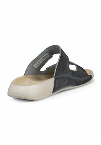 Zwarte lederen sandaal met uitgesneden zijkanten, zachte beige binnenzool en een ronde neus. Heeft een flexibele zool en minimale hardware.