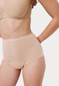 Beige hoge taille ondergoed met een gladde textuur en subtiele stikdetails, ontworpen voor comfort en een naadloze pasvorm.