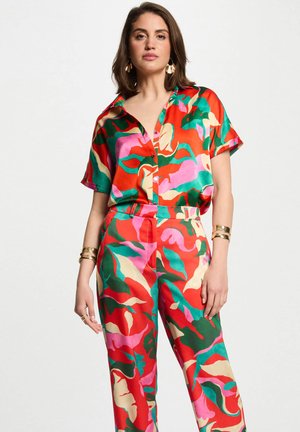 Set di top e pantaloni in satin multicolore con motivi floreali in rosso, verde, rosa e beige, caratterizzato da un colletto e maniche corte.
