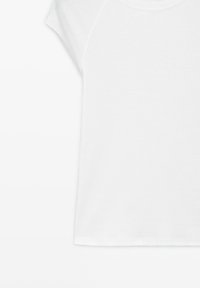 Effen wit T-shirt met korte mouwen en ronde hals, stoftextuur zichtbaar, plat liggend met lichte schaduwen en stikseldetails.