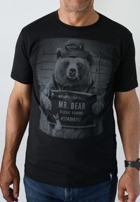 Black cotton t-shirt featuring a bear in police attire, holding a sign that says "MR. BEAR, ILLEGAL FISHING," with a mugshot backdrop.