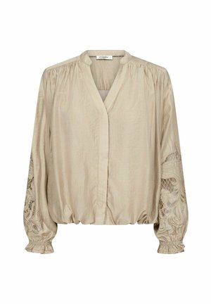 Blusa beige a maniche lunghe con polsini elastici arricciati, scollo a V, leggere pieghe sottili sulle spalle e ricamo in pizzo floreale traforato sulle maniche.