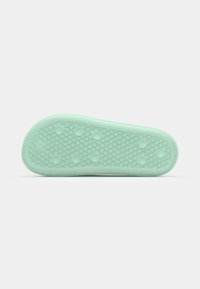 Mint green shoe sole with a textured surface, featuring a diamond pattern and circular accents for enhanced grip.