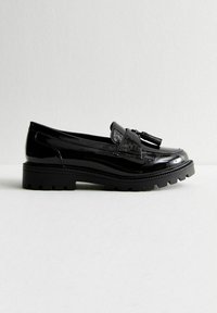 Svarta lackläders loafers med rund tå, dekorativa fransar och en kraftig gummisula med mönstrad sula.