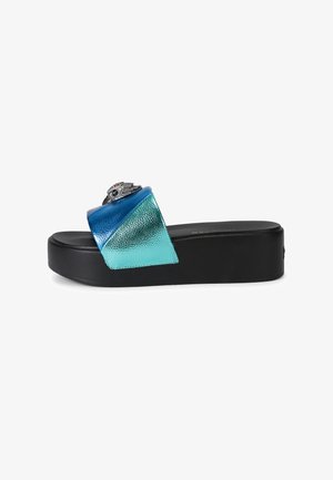 Zwarte platform-slidesandaal met een metallic blauw-groene band en zilveren versiering in de vorm van een gevleugelde oog bovenop.