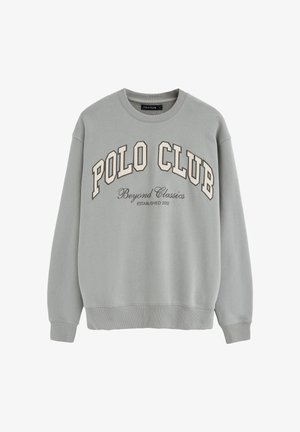 Light gray crewneck sweatshirt with "POLO CLUB" in large block letters and "Beyond Classics Established 2012" in smaller script below.