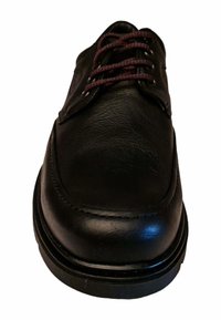 Zapato de vestir de cuero negro con puntera redonda, textura suave, suela marrón oscuro y cordones burdeos; costura visible a lo largo del borde.