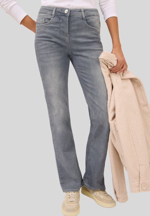Lichtblauwe denim jeans met een rechte pasvorm, voorzien van vijf zakken, een knoopsluiting en een lichte wassing, gecombineerd met een fluffy beige jasje.