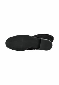 Stivale in suede nero visto dalla suola che mostra un tacco basso e un battistrada testurizzato per una buona aderenza.