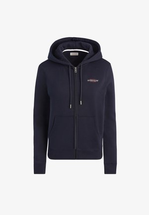 Tumšzilā ar rāvējslēdzi jaku, kas izgatavota no mīksta auduma, ar oderētu kapuci, divām priekšējām kabatām un mazu izšūtu logotipu uz krūtīm.