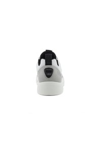 Sportlicher Schuh mit einem weißen und grauen Farbschema, strukturiertem Gummisohlen, Obermaterial aus Stoff und einer schwarzen Zuglasche am Fersenbereich.