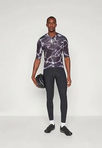 Αθλητική στολή ποδηλασίας που περιλαμβάνει ένα κοντομάνικο φανελάκι με φερμουάρ με σχέδιο νερού σε μαύρο και γκρι χρώμα, συνδυασμένο με μαύρα κολάν και παπούτσια ποδηλασίας.