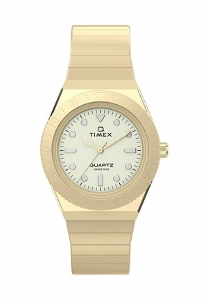 Auksinio atspalvio Timex Q laikrodis su baltu ciferblatu, šviečiančiais žymekliais ir metaline grandinėlės apyranke, rodantis laiką 10:11:10.