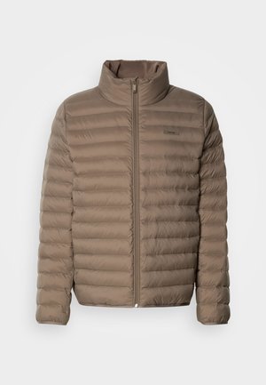 Giacca imbottita di colore marrone chiaro con trapuntatura orizzontale, colletto alto e zip anteriore. Presenta un'etichetta con logo sul lato superiore sinistro.