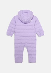 Violetinė pūkinė snowsuit su gobtuvu, su kvadratine siuvinėta išvaizda, elastingomis rankovėmis ir logo gale. Minkšta, šiltinanti medžiaga patogumui.