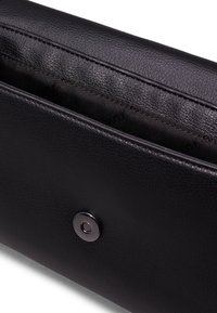 Černá kožená peněženka s hladkou texturou, vybavená stříbrným zapínacím knoflíkem a podšitým vnitřkem s jemným logem.