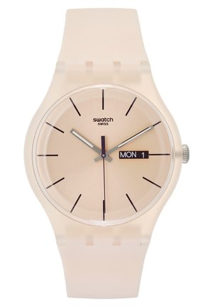 Montre Swatch beige avec index noirs, aiguilles argentées, trotteuse centrale violette et affichage jour-date indiquant lundi 1er.