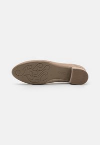 Suela de zapato de ante beige con un patrón de agarre texturizado. Presenta un leve tacón y un acabado suave. Nombre de la marca "Gabor" grabado en el costado.