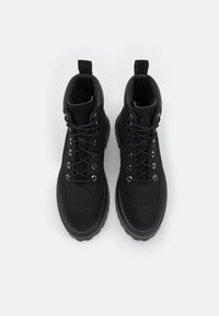 Zwarte enkellaarzen met een robuust ontwerp, voorzien van een gladde textuur, ronde neus, vetersluiting aan de voorkant en een lipje aan de hiel voor gemakkelijk aan- en uittrekken.