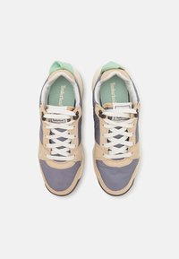 Sportschuhe in Beige, Dunkelblau und Hellgrün. Aus Wildleder und synthetischem Material mit weißen Schnürsenkeln und gepolstertem Zungenbereich für Komfort.