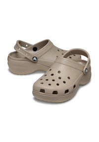 Crocs beige dal design leggero, con molteplici fori di ventilazione, una fascia testurizzata e una cinghia sul retro per una vestibilità sicura.
