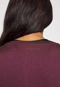 Marloburgunder athletic shirt med rund hals, korte ærmer og et subtilt "ONLY PLAY" design på bagsiden. Glat, letvægtsstof.