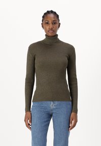 Dark olive green ribbed turtleneck sweater, fitted design with long sleeves, soft texture, paired with light blue jeans.
