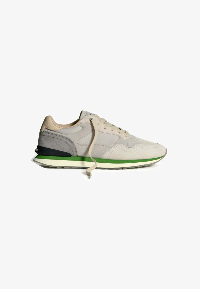 Beige ruskind sneakers med en struktureret overdel, snørebåndslukning, grønne og sorte accenter samt en tyk hvid skumgummisål.