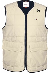 Beige vadderad väst med en marinblå krage, dragkedja framtill, två stora framfickor och en liten logotyp på bröstet.