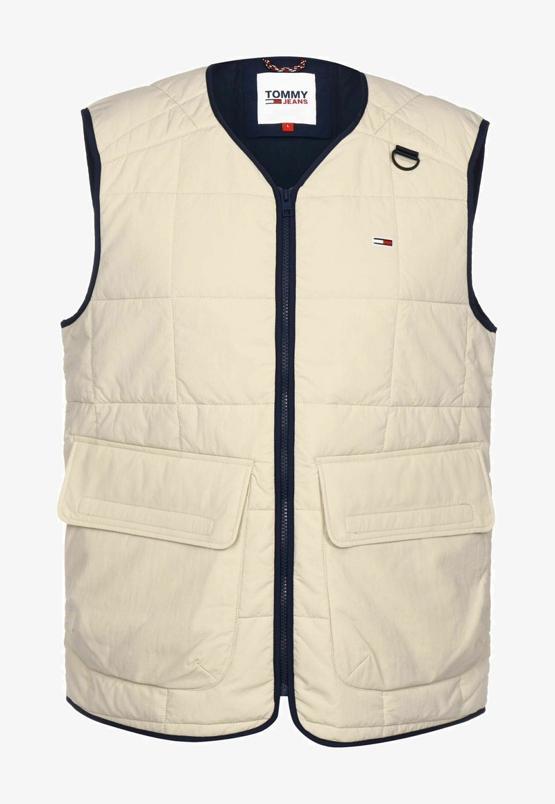 Beige vadderad väst med en marinblå krage, dragkedja framtill, två stora framfickor och en liten logotyp på bröstet.