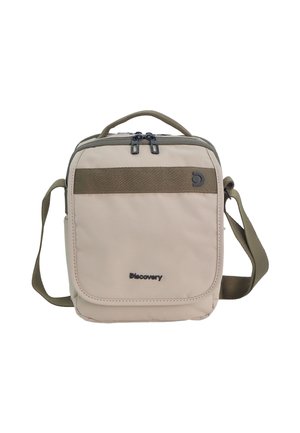 Compact beige crossbody bag with green strap, top handle, dual zipper, front pocket, and "Discovery" brand logo on front.