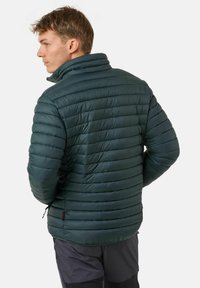 Giacca a vento verde scuro con texture trapuntata orizzontale, colletto alto e design leggero, dotata di chiusura con zip e tasche.