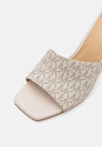 Beige Sandale mit offenem Zehenbereich, breitem gemustertem Riemen und quadratischem Zehen-Design, ausgestattet mit einem strukturierten Stoff und einem glatten Innenfutter.