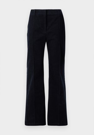 Tummansinisiä corduroy-housuja, joissa on lahkeet, jotka levenevät alaosastaan. Housuissa on kaksi etutaskua ja näkyvä ompelu saumoissa. Pintamateriaali on sileä.