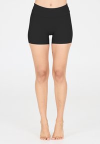 Shorts de compression noirs avec une large ceinture, texture lisse et design ajusté, arrivant au milieu de la cuisse. Coutures minimales et aucun matériel visible.