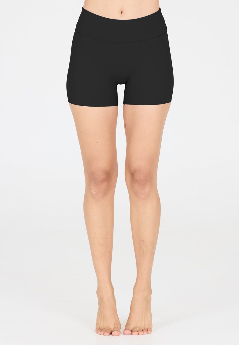 Shorts de compression noirs avec une large ceinture, texture lisse et design ajusté, arrivant au milieu de la cuisse. Coutures minimales et aucun matériel visible.