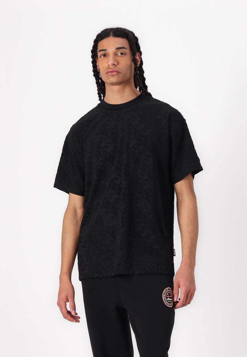 Tricou negru cu mâneci scurte, cu un model subtil, decolteu rotund și croială lejeră, asortat cu pantaloni negri care au un logo colorat.