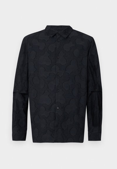 Mörk marinblå långärmad skjorta i tyg med en subtil texturerad mönster, spetskrage och knappstängning framtill.