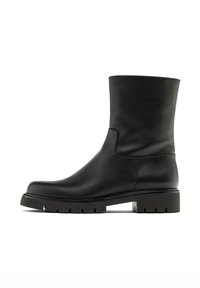 Černá kožená kotníková bota s hladkým povrchem, zaoblenou špičkou, nízkou platformou a robustní podešví s drážkováním. Elegantní a minimalistický design.