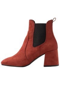 Botte de cheville en daim couleur rouille avec talon bloc, bout pointu, panneau latéral élastique noir et languette à l'arrière.