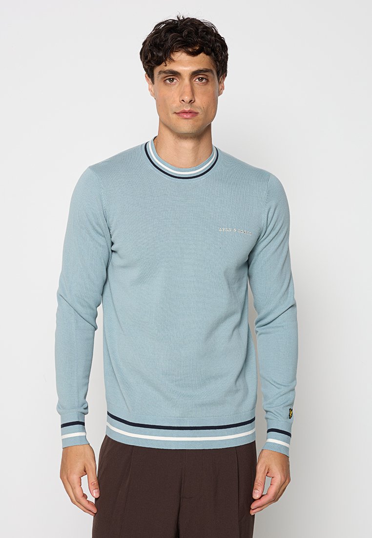 Maglione a maniche lunghe a coste di colore blu chiaro con collo e polsini a righe in contrasto. Presenta un piccolo dettaglio del logo sul petto.