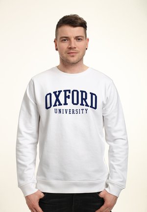 Felpa bianca in cotone con polsini e orlo a coste, caratterizzata da una stampa centrale in blu navy "OXFORD UNIVERSITY" sul davanti.