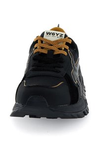 Scarpe da ginnastica nere con tomaia in tessuto testurizzato, logo nero audace, lacci beige a contrasto e suola robusta per migliorare la trazione.
